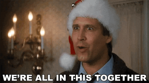 a man wearing a santa hat is saying we 're all in this together .