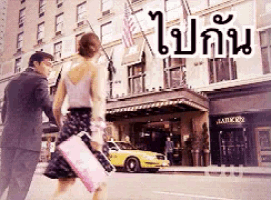 a man and a woman are walking down a street in front of a building that says ' market ' on it