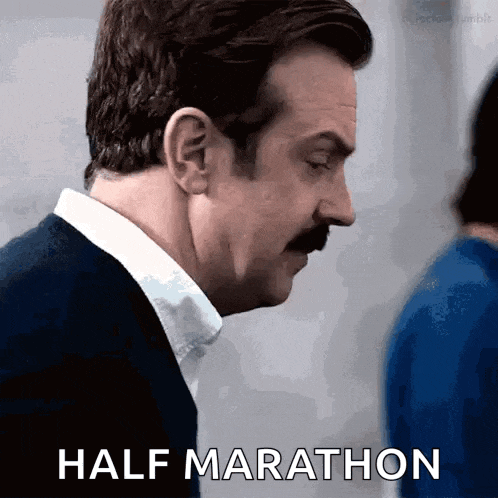 a man with a mustache is saying " half marathon "