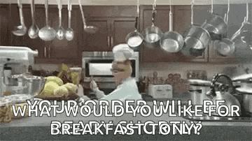 a chef is cooking in a kitchen with pots and pans hanging from the ceiling and a blender .