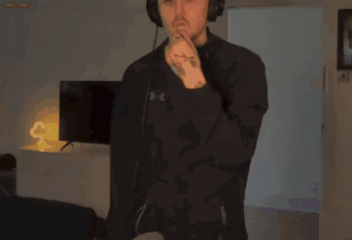 a man wearing headphones is making a funny face in front of a tv screen
