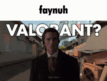 a man in a suit and tie is standing in front of a sign that says " valorant "