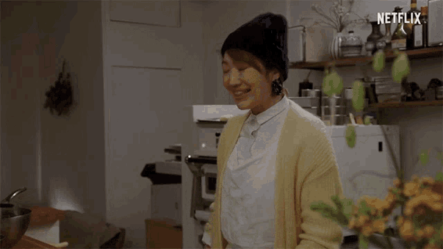 a woman in a kitchen says welcome in front of a sign that says netflix
