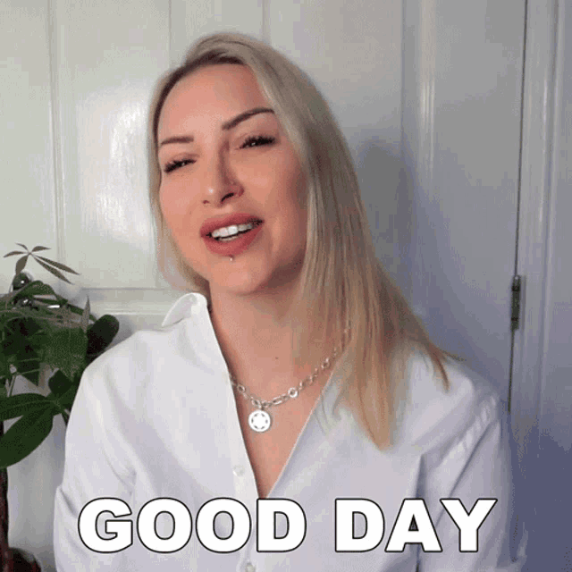 a woman wearing a white shirt and a necklace says good day