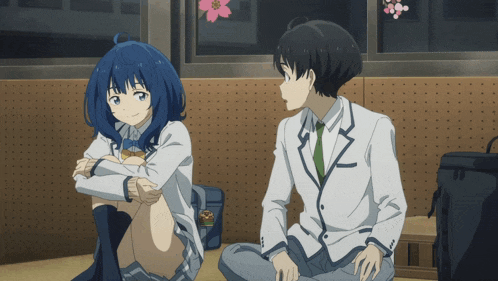 a boy and a girl sit next to each other in front of a window