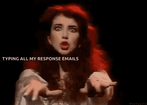 a woman with red hair is making a funny face while typing all of her response emails .