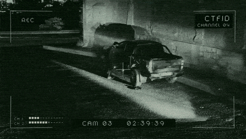 a black and white photo of a car being recorded by a camera
