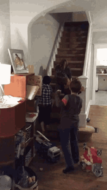a group of children are playing on a set of stairs in a cluttered room