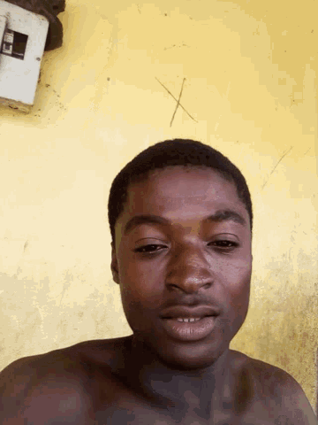 a man without a shirt is smiling and looking at the camera