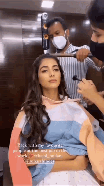 a woman is sitting in a chair getting her hair done by a hairdresser .