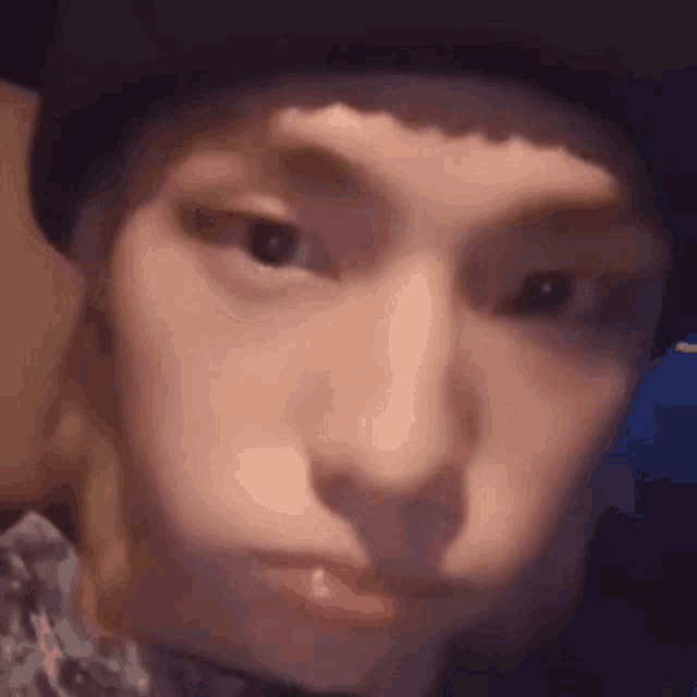 a close up of a person wearing a hat and making a funny face .
