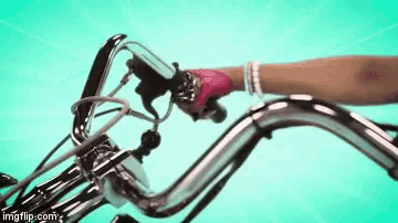 a person is riding a bicycle with a pink glove on .