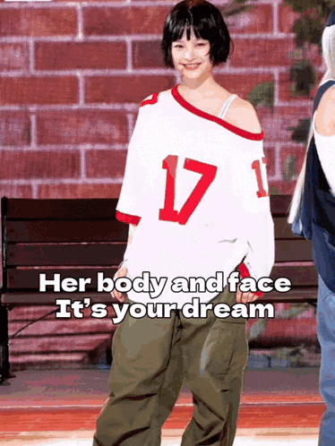 a girl wearing a number 17 jersey is standing in front of a bench
