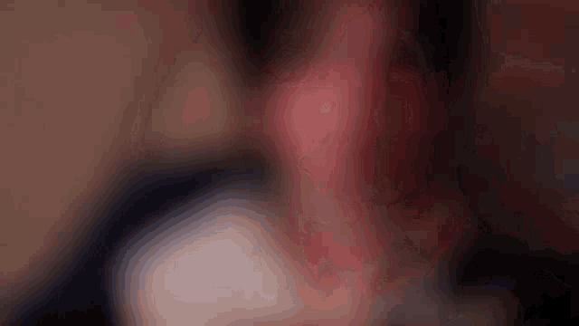 a blurry picture of a person 's face with a red ear