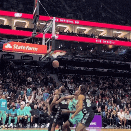 a basketball game is being played in front of a state farm advertisement