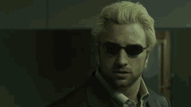 a man with blonde hair wearing sunglasses and a black jacket
