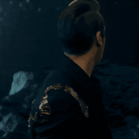 a man is wearing a black jacket with gold sleeves