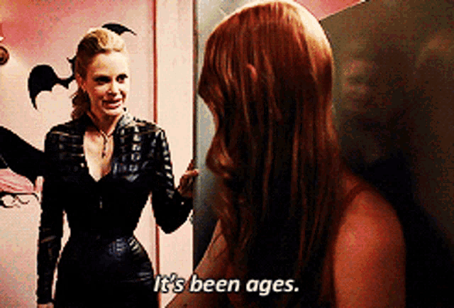 two women are standing next to each other and one of them says " it 's been ages "