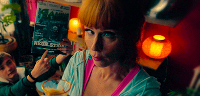 a woman holds up a magazine that says neon storm