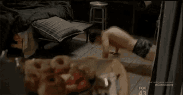 a man is doing push ups in a room with a fox logo in the background