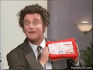a man in a suit and tie is holding a piece of cheese .