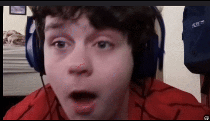 a young boy wearing headphones and a red shirt looks surprised .