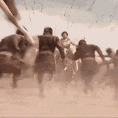 a group of people riding horses in the dirt .