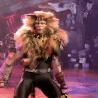 a man in a lion costume is dancing on stage .