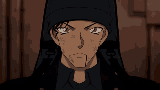 a man with a beard wearing a black hat and a black jacket with the letter h on it