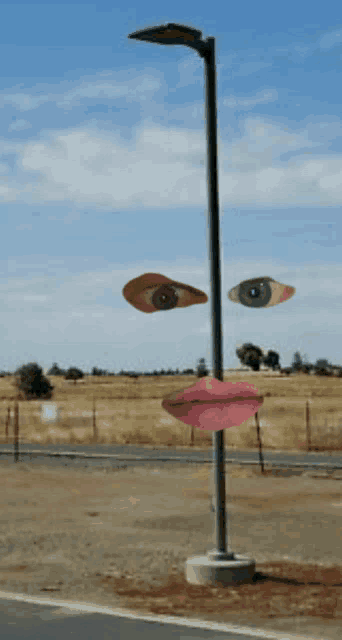 a street light with three faces on it including eyes and lips