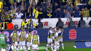 a bunch of soccer players are on a field with a burger king sign in the background