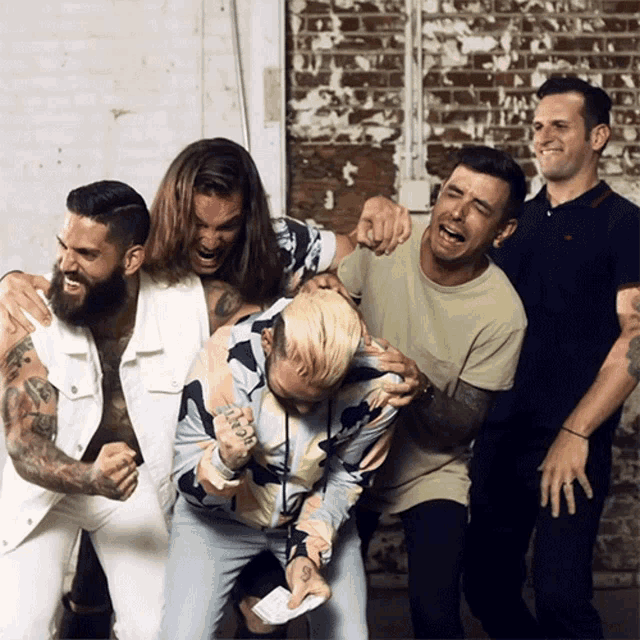 a group of men are posing for a picture and one has a tattoo on his arm that says ' i love you ' on it