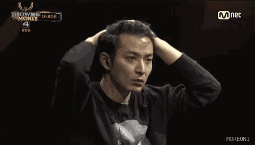 a man adjusts his hair while watching a show called show me money 4