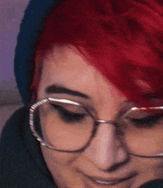 a close up of a woman wearing glasses and a hat .