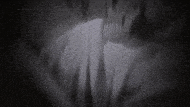 a black and white photo of a person 's face in the dark