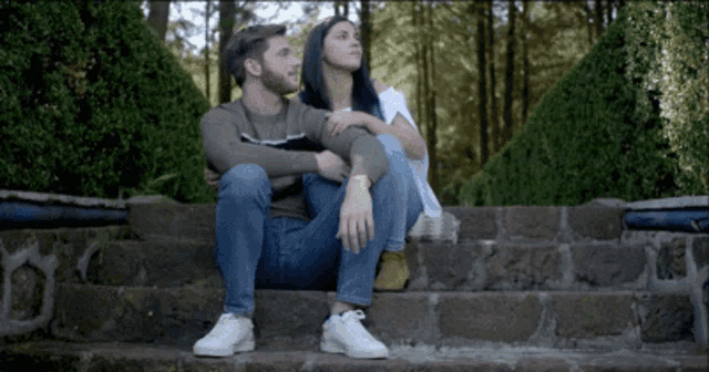 a man and a woman are sitting on a set of steps