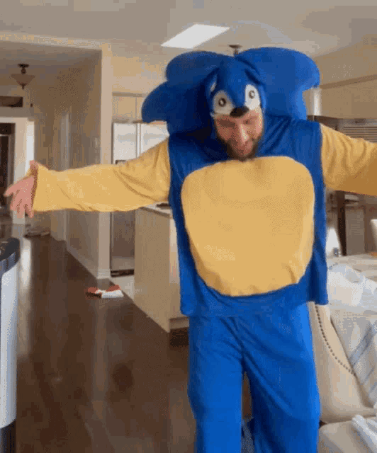 a man in a blue and yellow sonic costume is standing in a living room