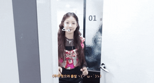 a girl is standing in a doorway with the number 01 on it