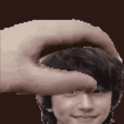 a pixelated image of a person 's head with a hand on it