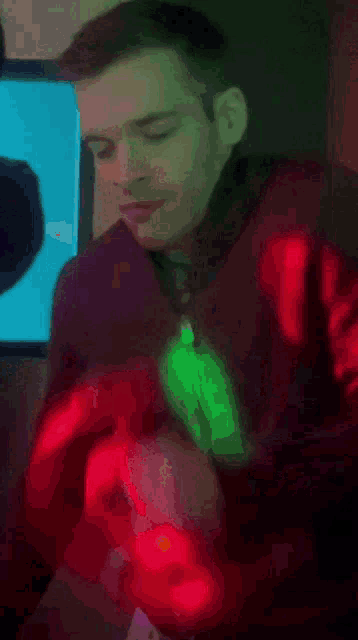 a man in a dark room with a green light behind him