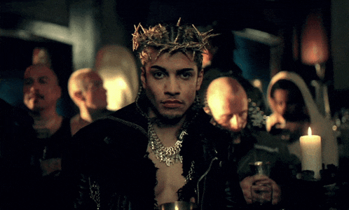 a man with a crown of thorns on his head stands in a crowd of people