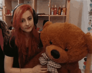 a woman wearing headphones holds a teddy bear