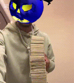 a man wearing a blue mask is holding a large stack of money