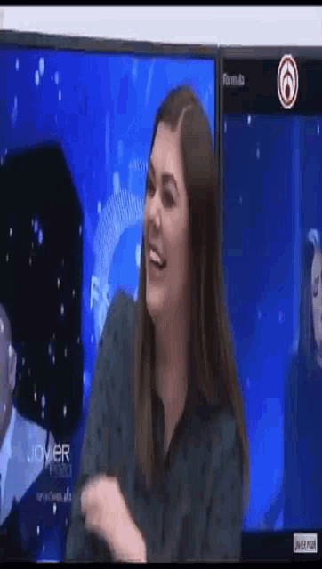 a woman is smiling in front of a formula television