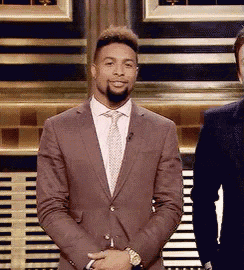 a man in a suit and tie stands next to another man