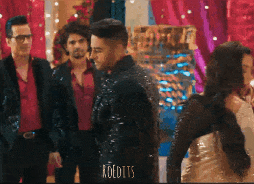 a man in a sequined jacket is standing next to a woman