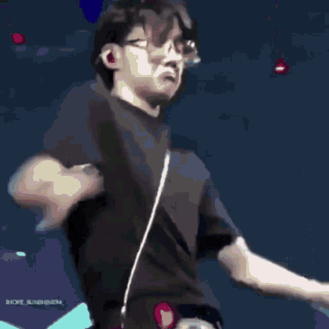 a man in a black shirt is dancing on a stage .