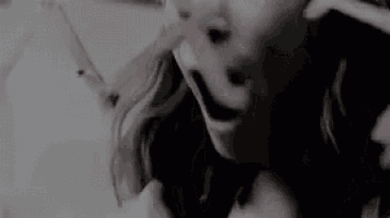 a close up of a woman 's face with her finger in her nose .