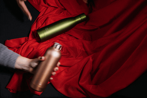 a person is holding a bottle that says stainless steel
