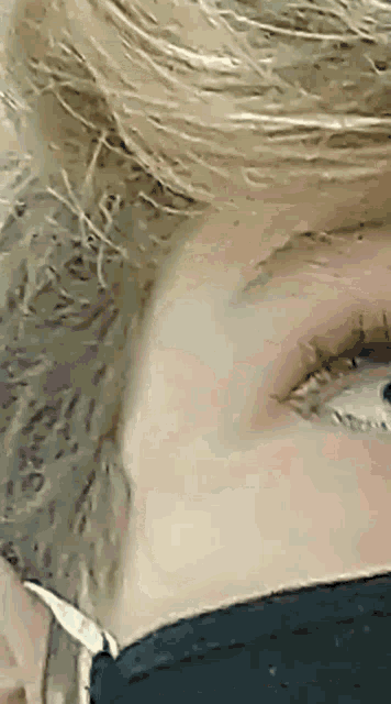 a close up of a person 's face with a black shirt on